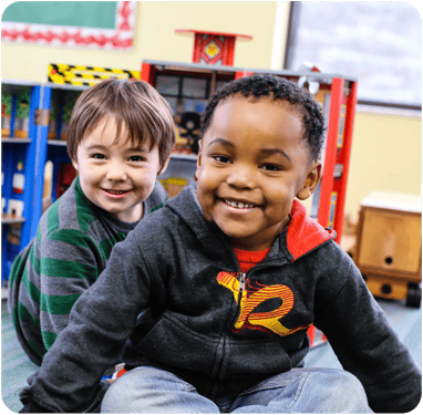 Two children smiling in a classroom