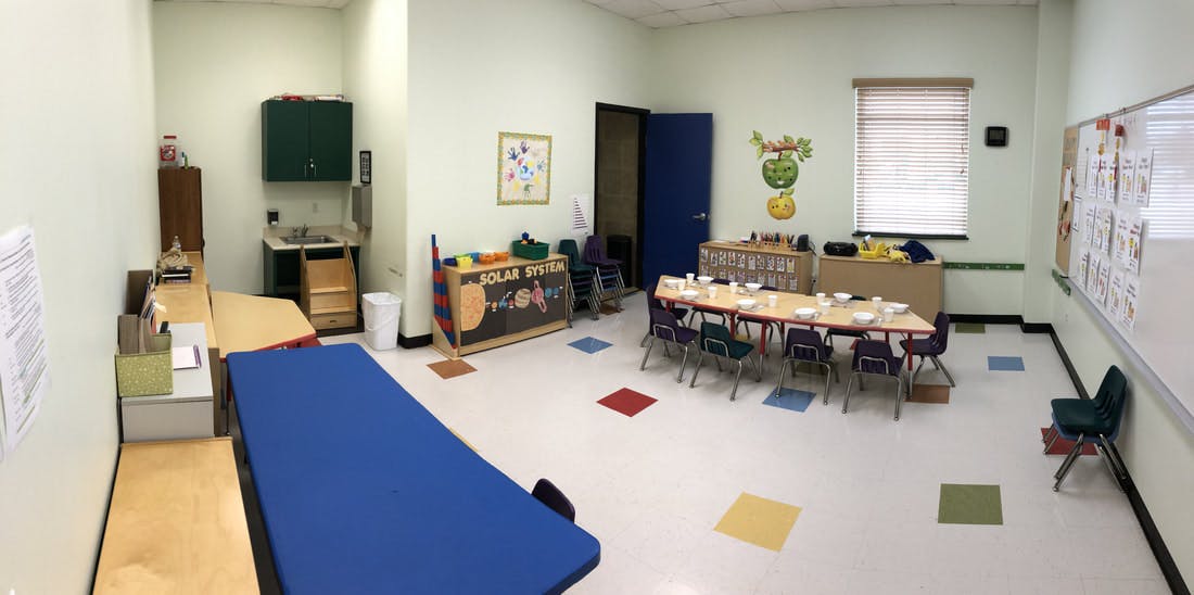 Empty classroom with small tables and chairs