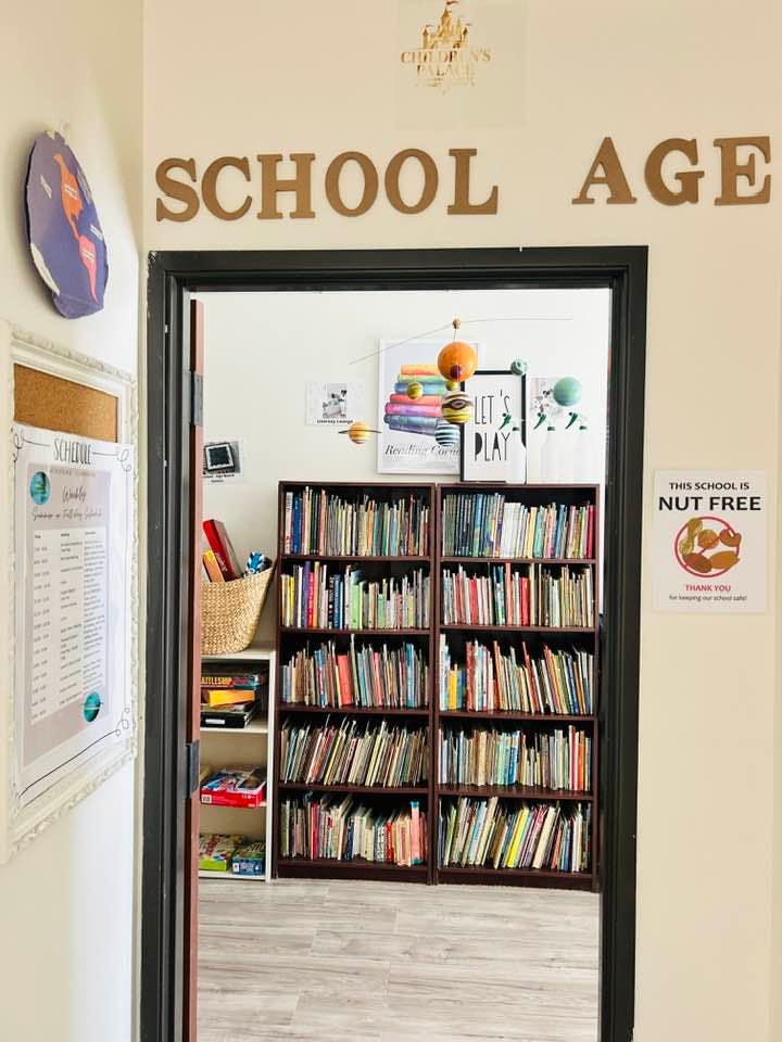 Doorway with "SCHOOL AGE" sign above, leading to a room with bookshelves
