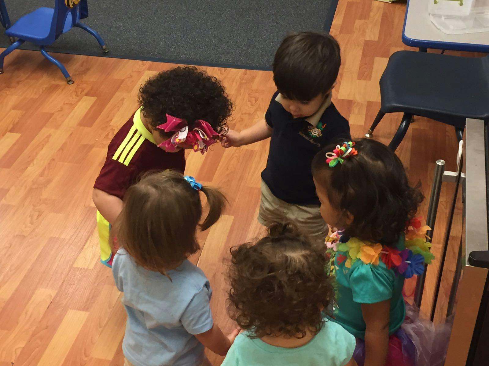 Four children standing in a circle, holding hands