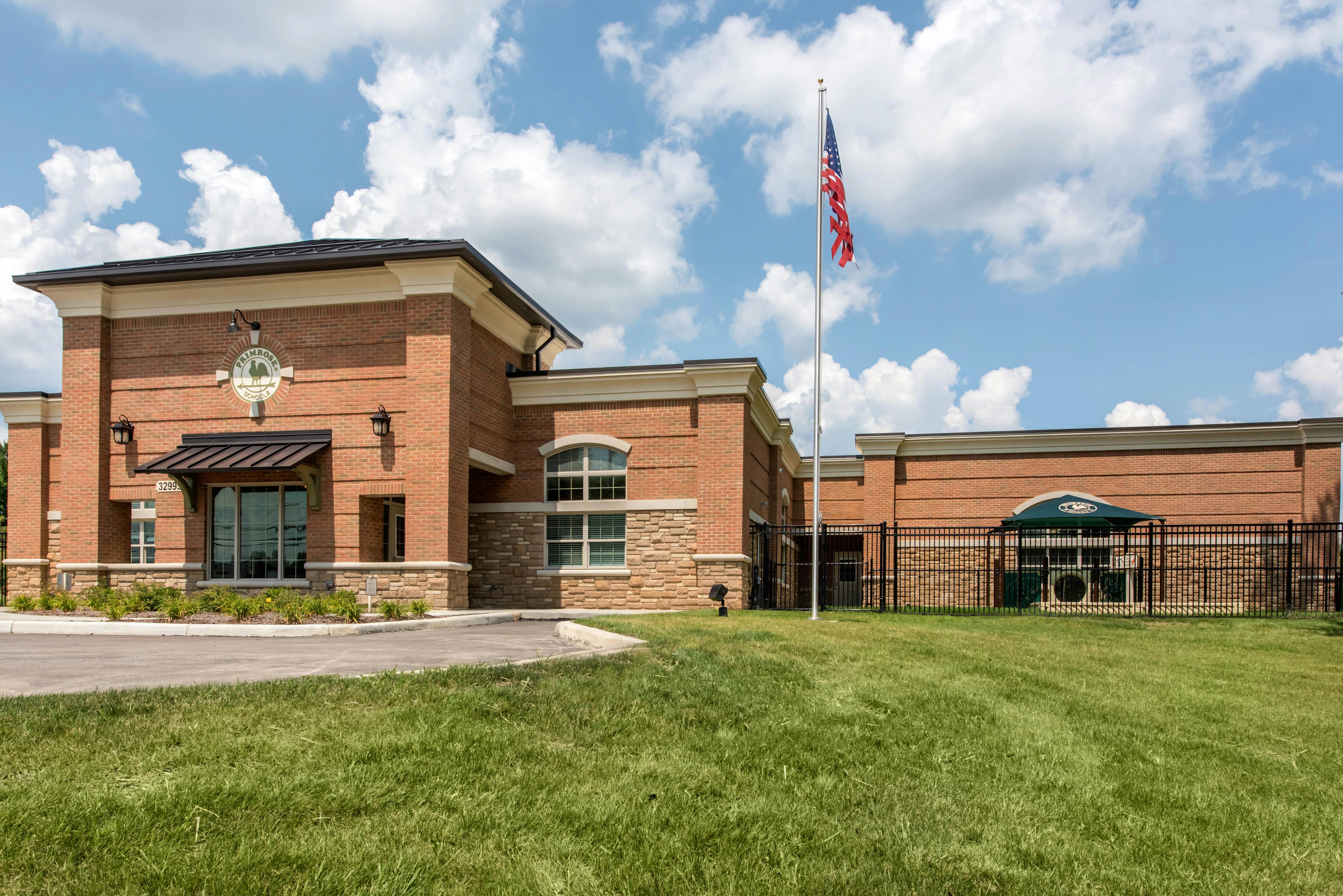 Primrose Schools building with an American flag and green awning