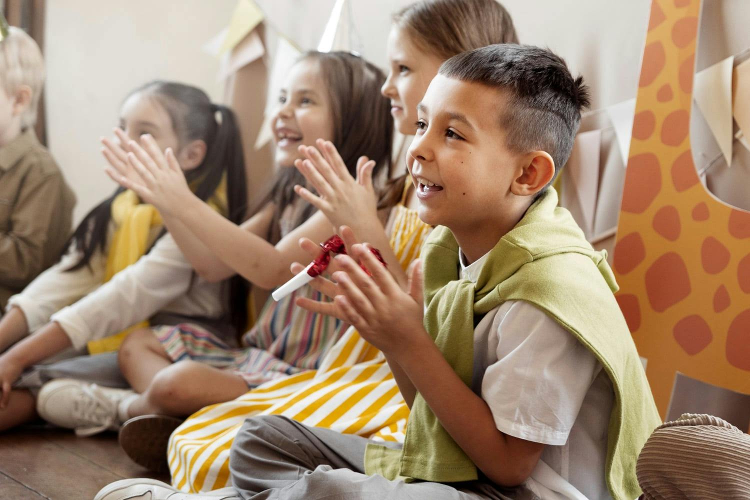 Group of children sitting on the floor and clapping