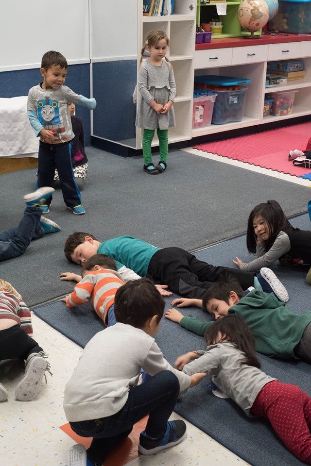 Children playing on the floor in a classroom