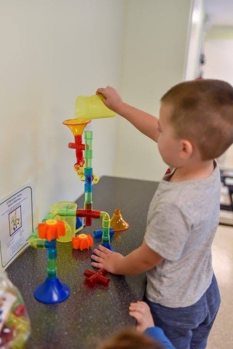 Child playing with a colorful marble run toy