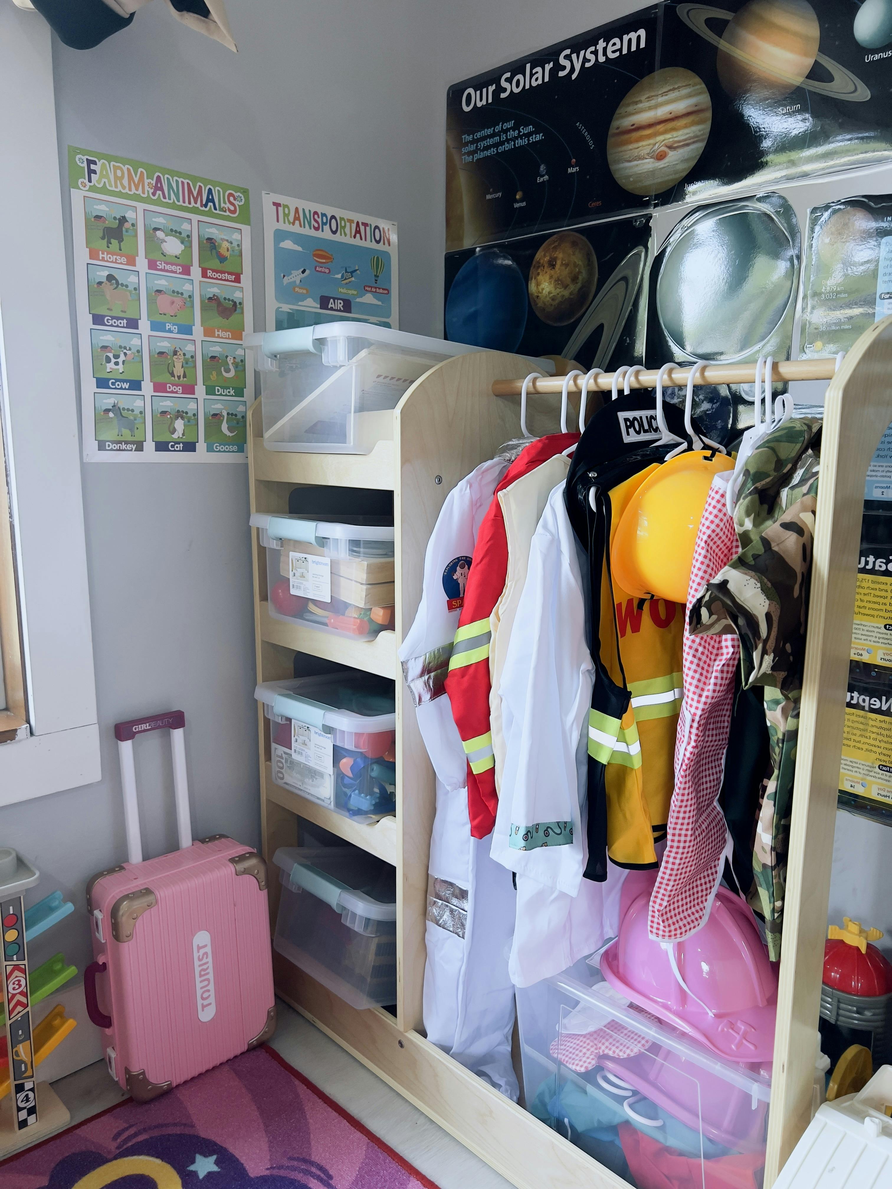 Dress-up rack with costumes, storage bins, and educational posters