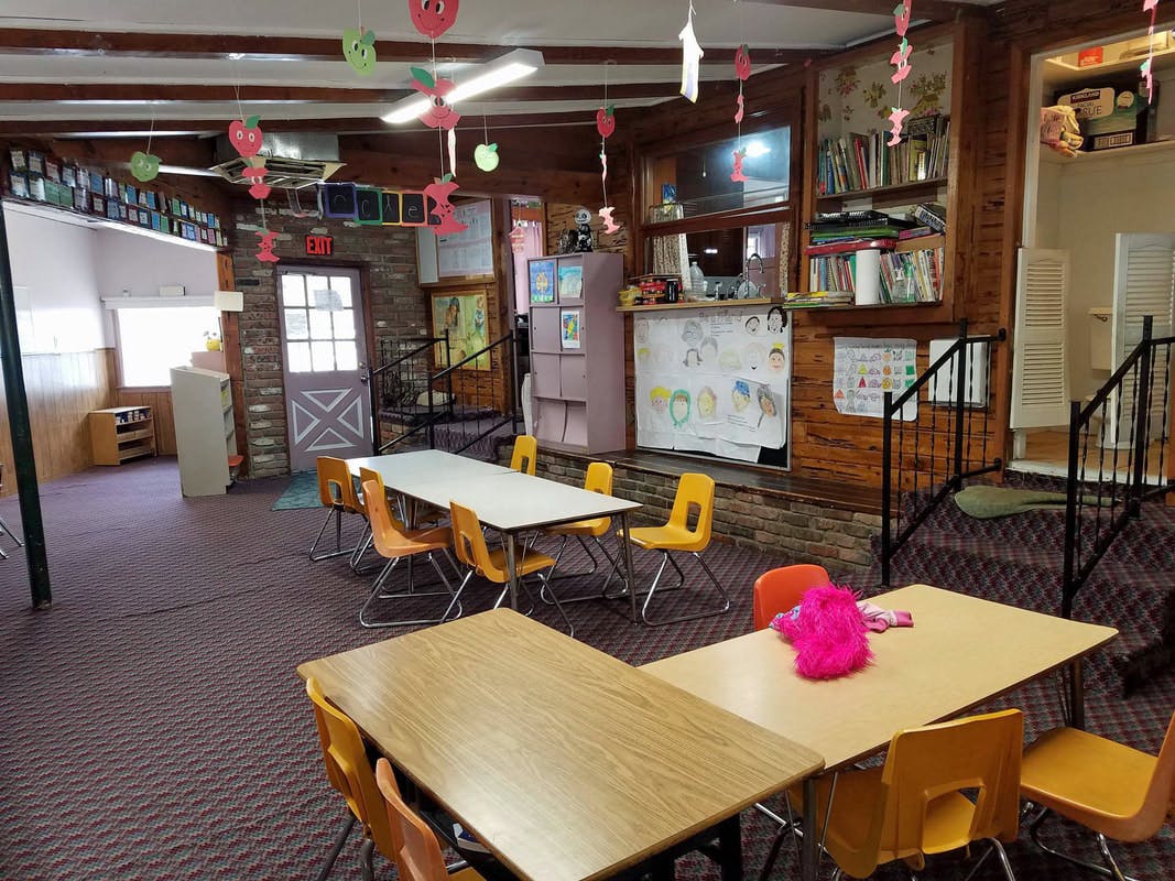 Classroom with tables and chairs, decorated with hanging cutouts