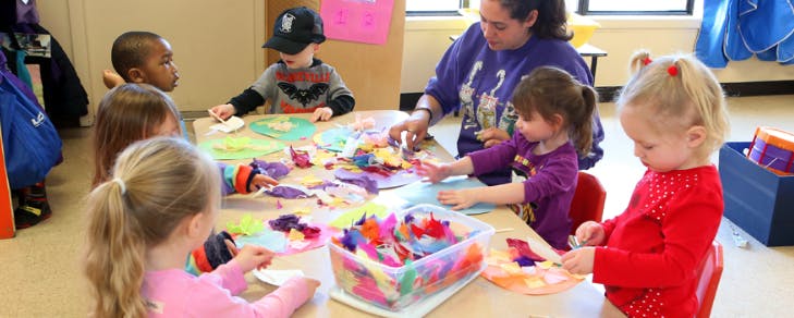 Adult and children doing crafts at a table