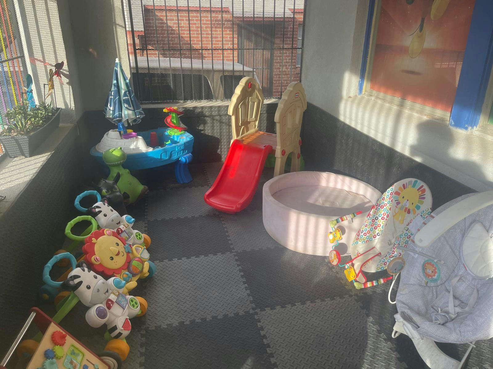 Children's play area with toys, a slide, and a ball pit