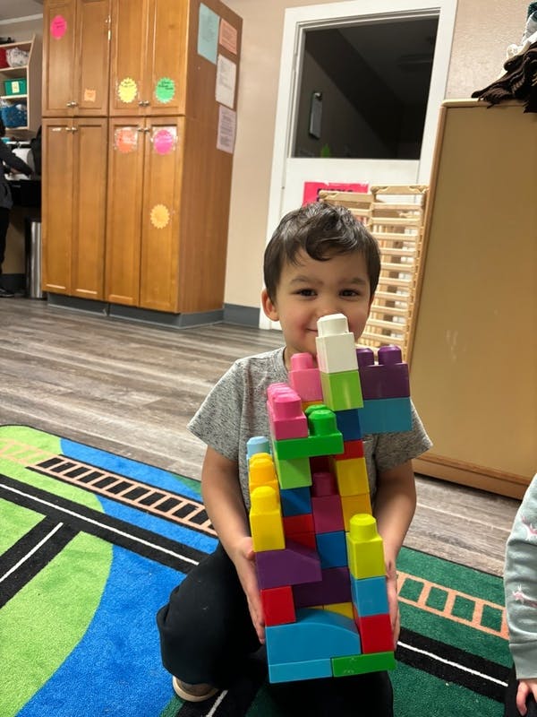 Child holding a colorful block tower