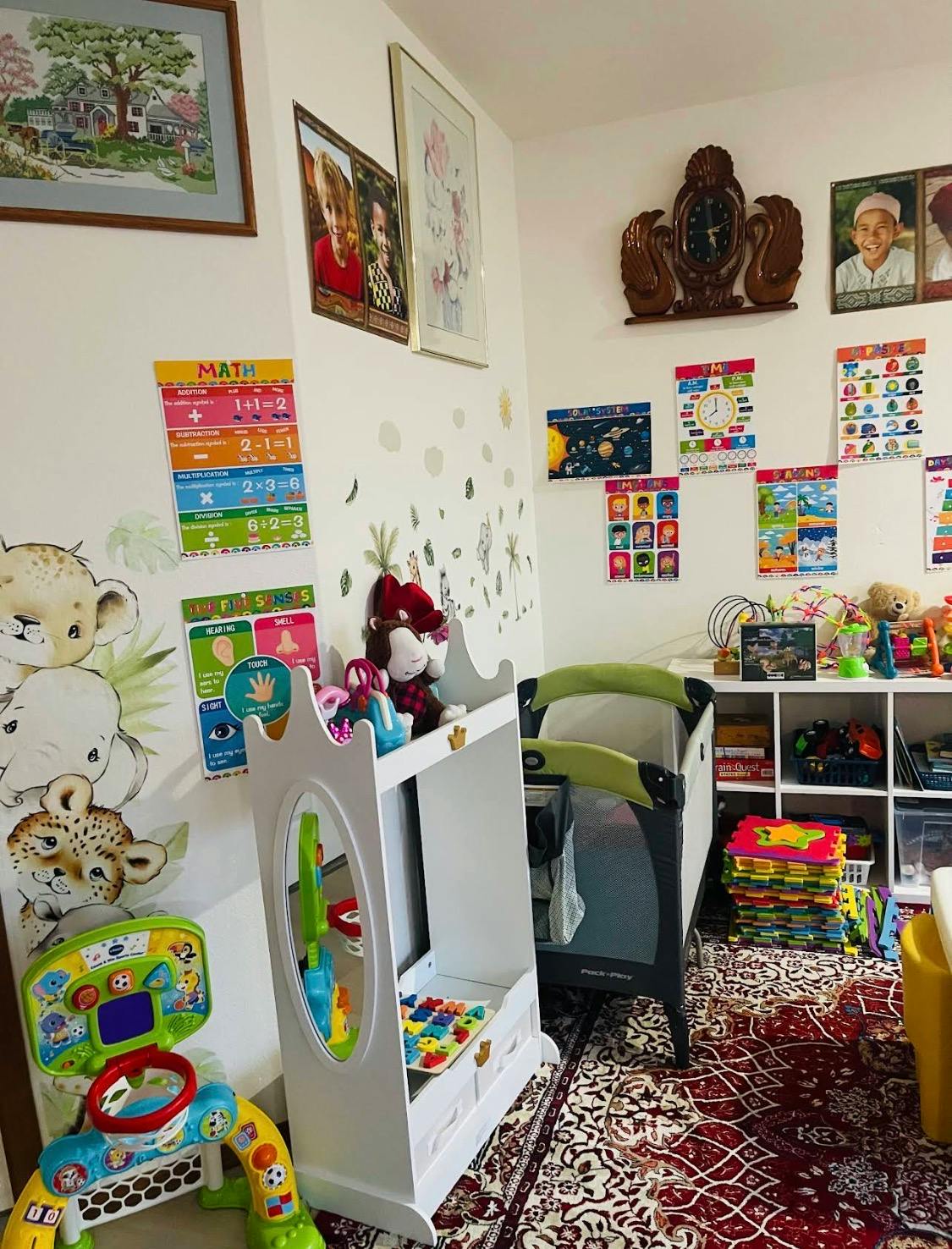 A playroom with colorful educational posters on the walls, a crib, and various toys