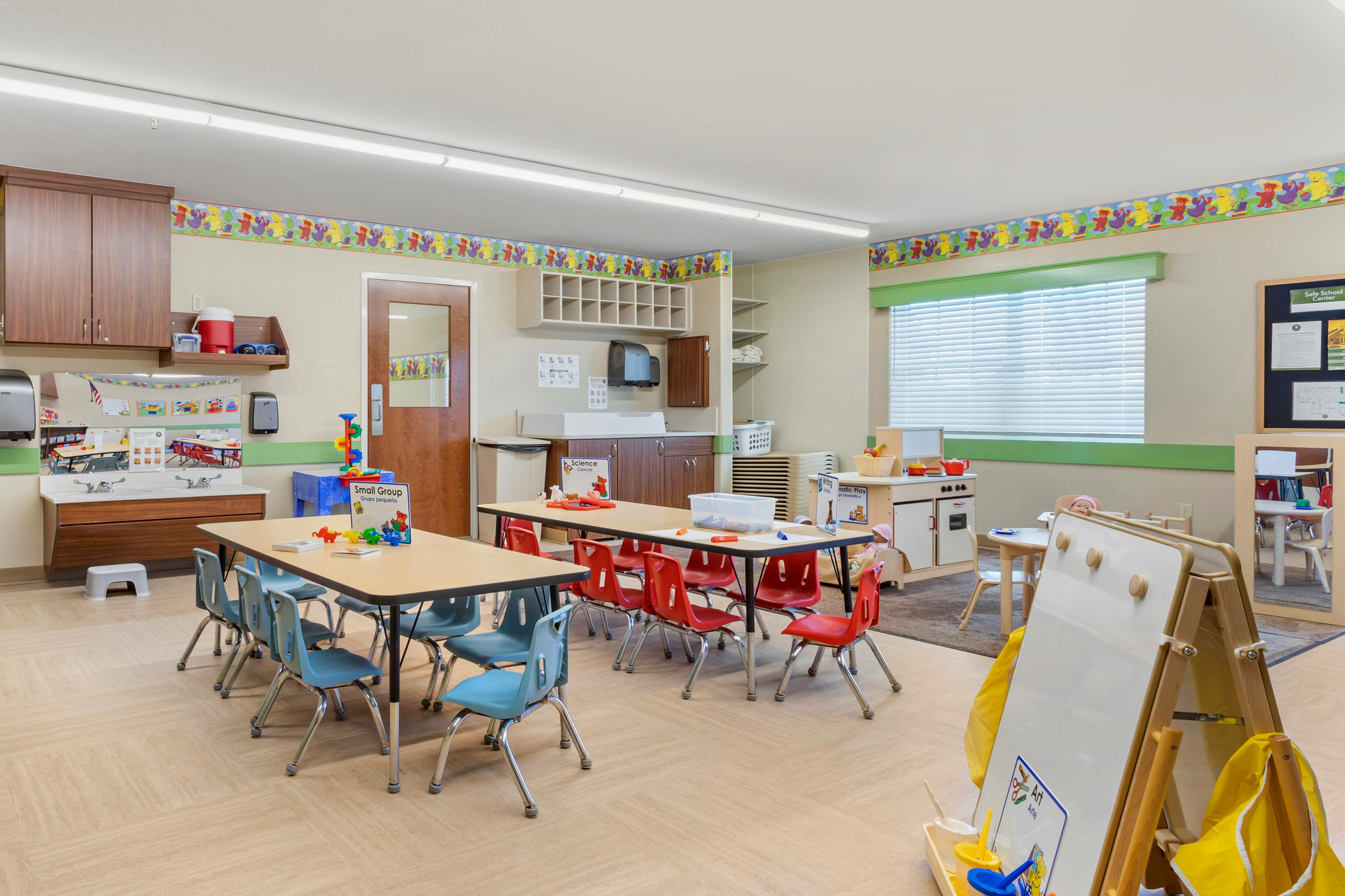Classroom with tables, chairs, sinks, and play areas
