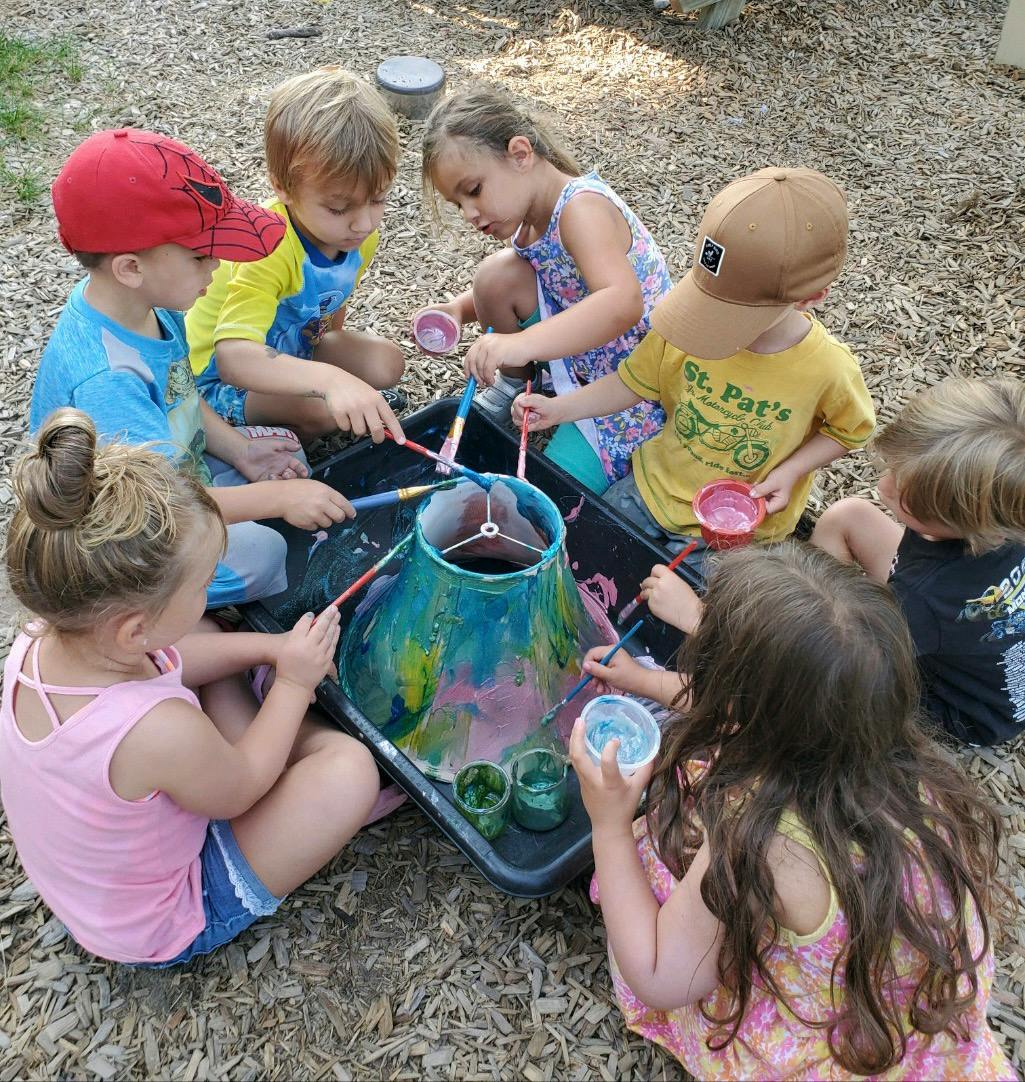 Group of children painting a lamp shade