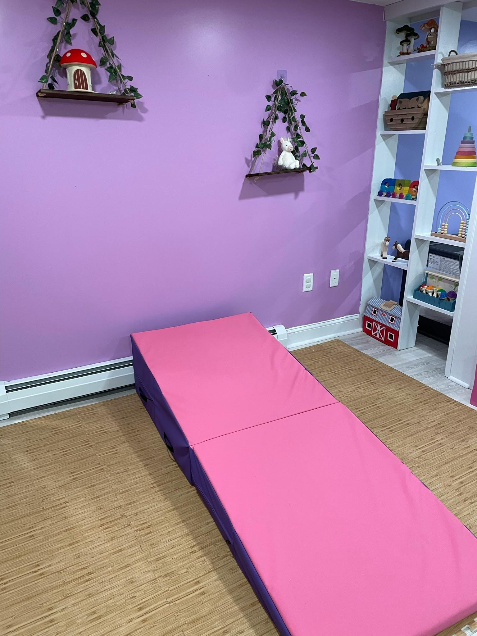 Pink and purple incline mat on a rug in a room with purple walls