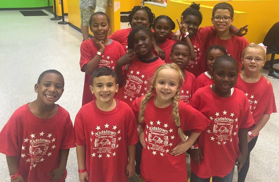 Group of children in red t-shirts with a white logo