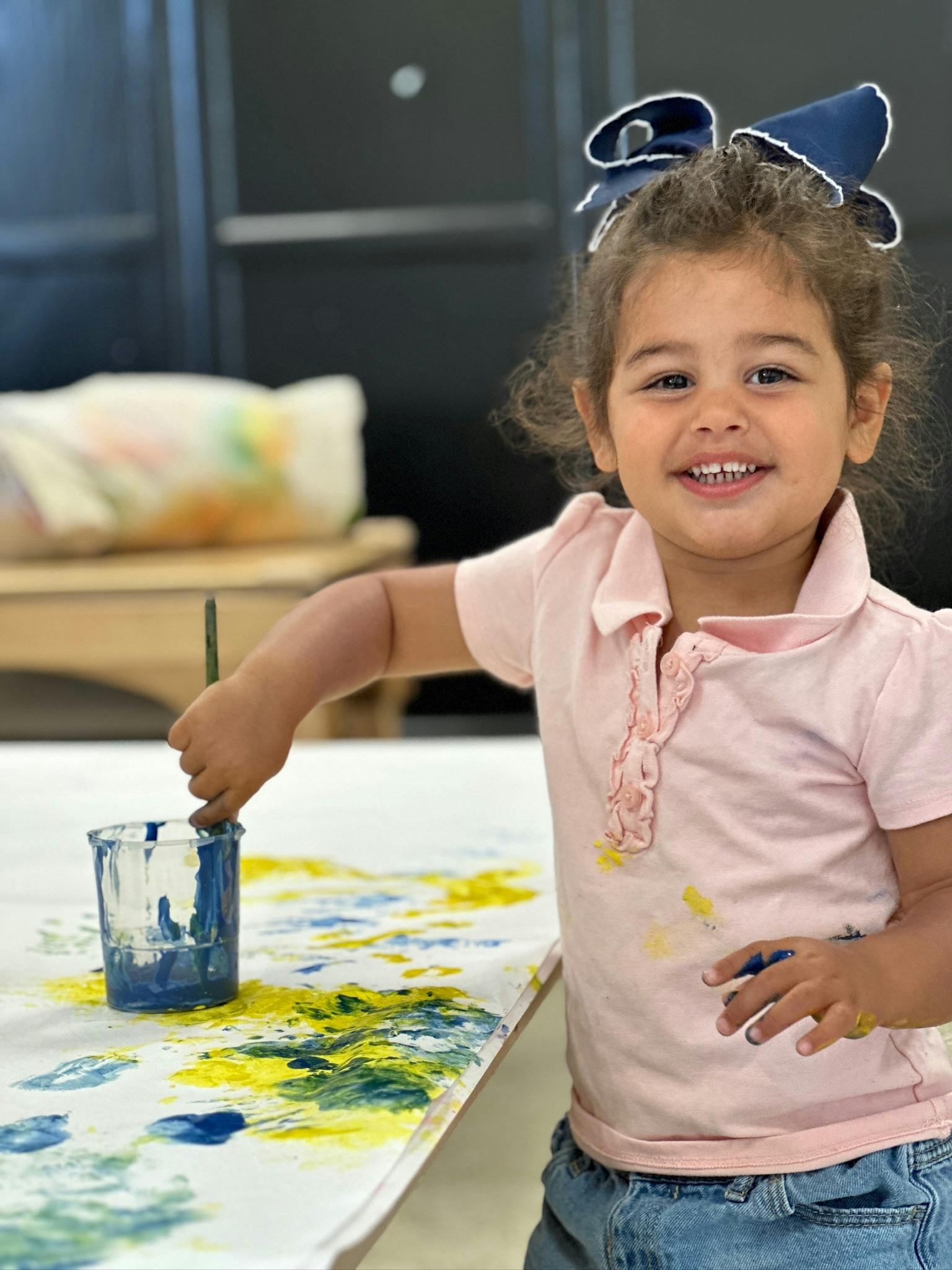 Child painting with blue and yellow paint