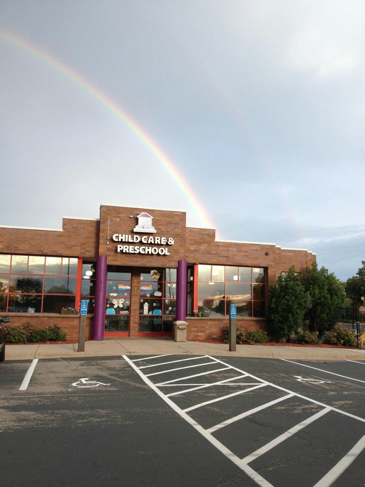 Rainbow over a building with "Child Care & Preschool" sign
