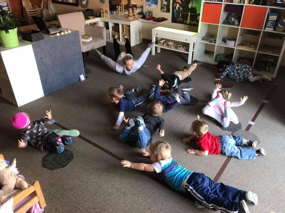 Adult and children lying on the floor in a room