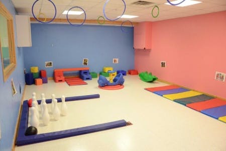 Playroom with bowling pins, colorful mats, and play equipment