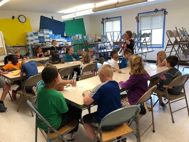Children sitting at tables in a classroom