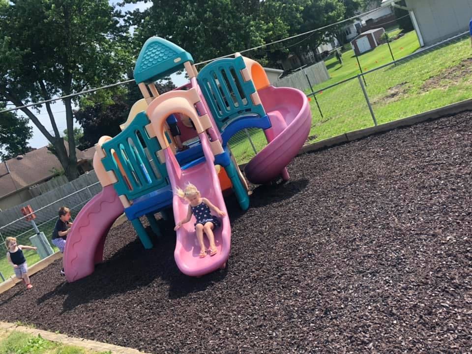 Child on a pink slide at a playground