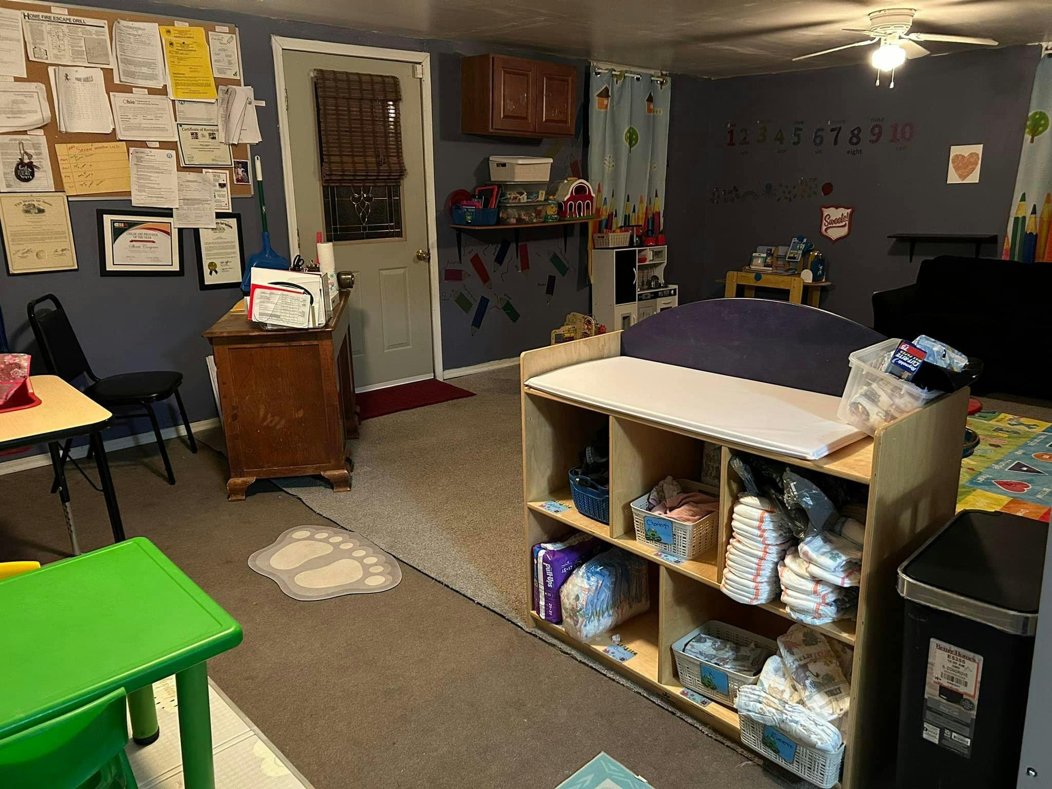 Changing table with diapers and supplies in a room with a bulletin board