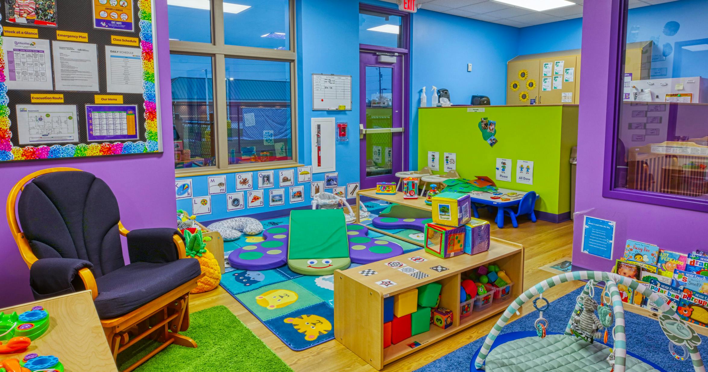 Colorful playroom with cribs, play mats, and small tables