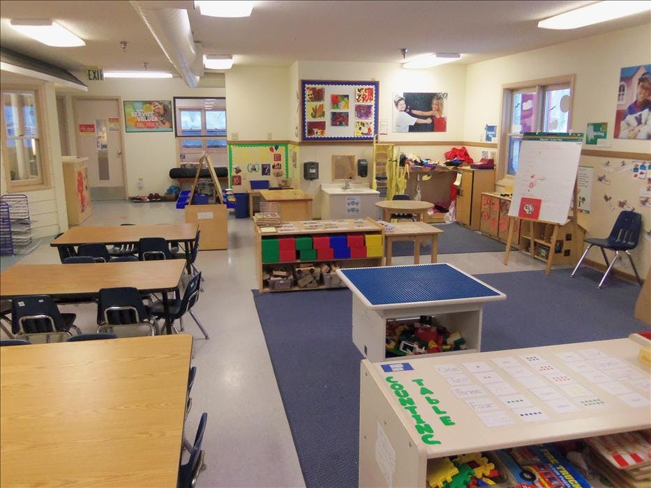 Classroom with tables, chairs, teaching aids, and play areas