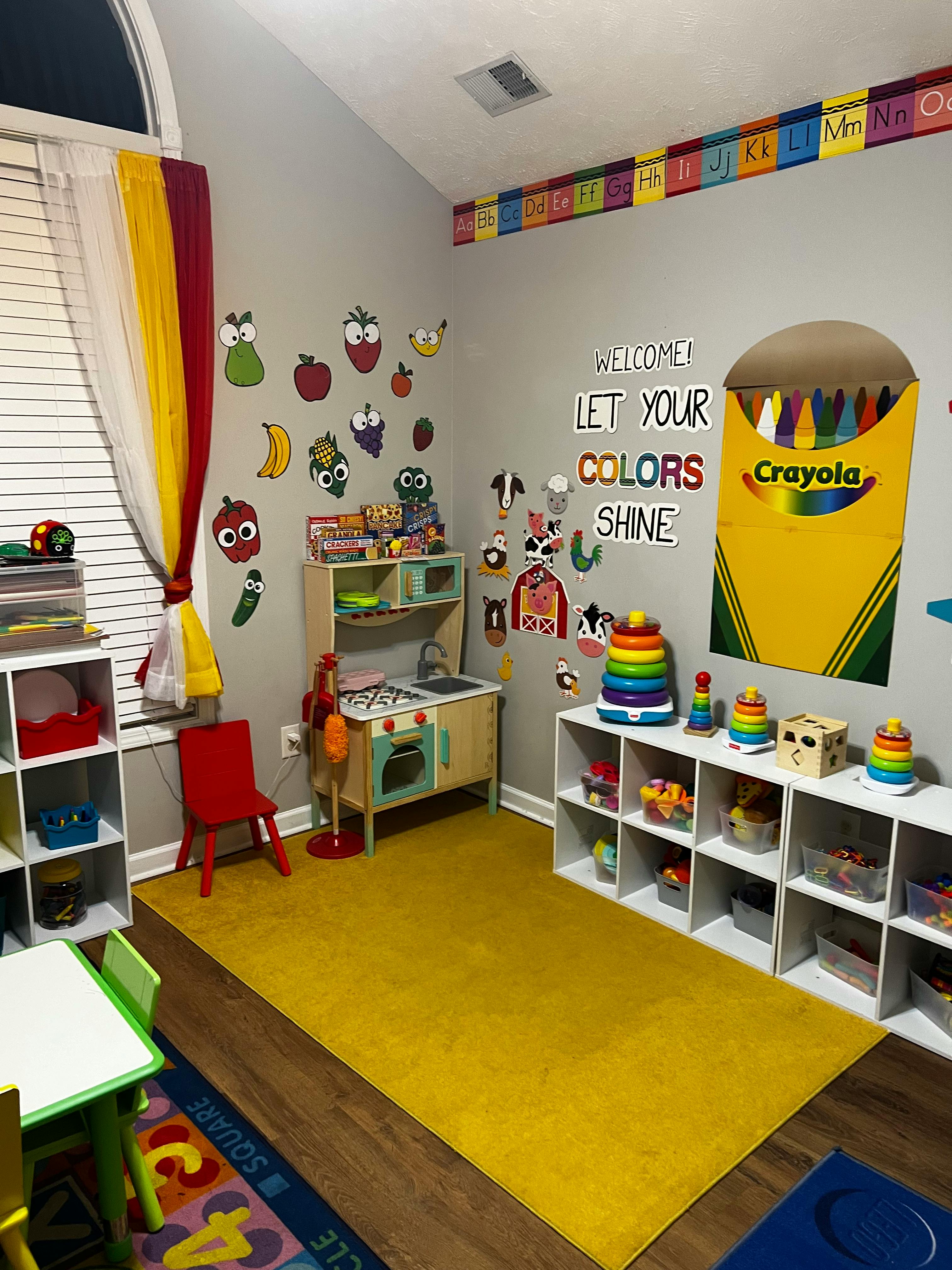 Playroom with toy kitchen, shelves of toys, and wall decorations