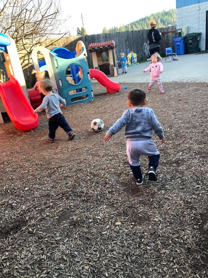 Children playing with a soccer ball on a playground