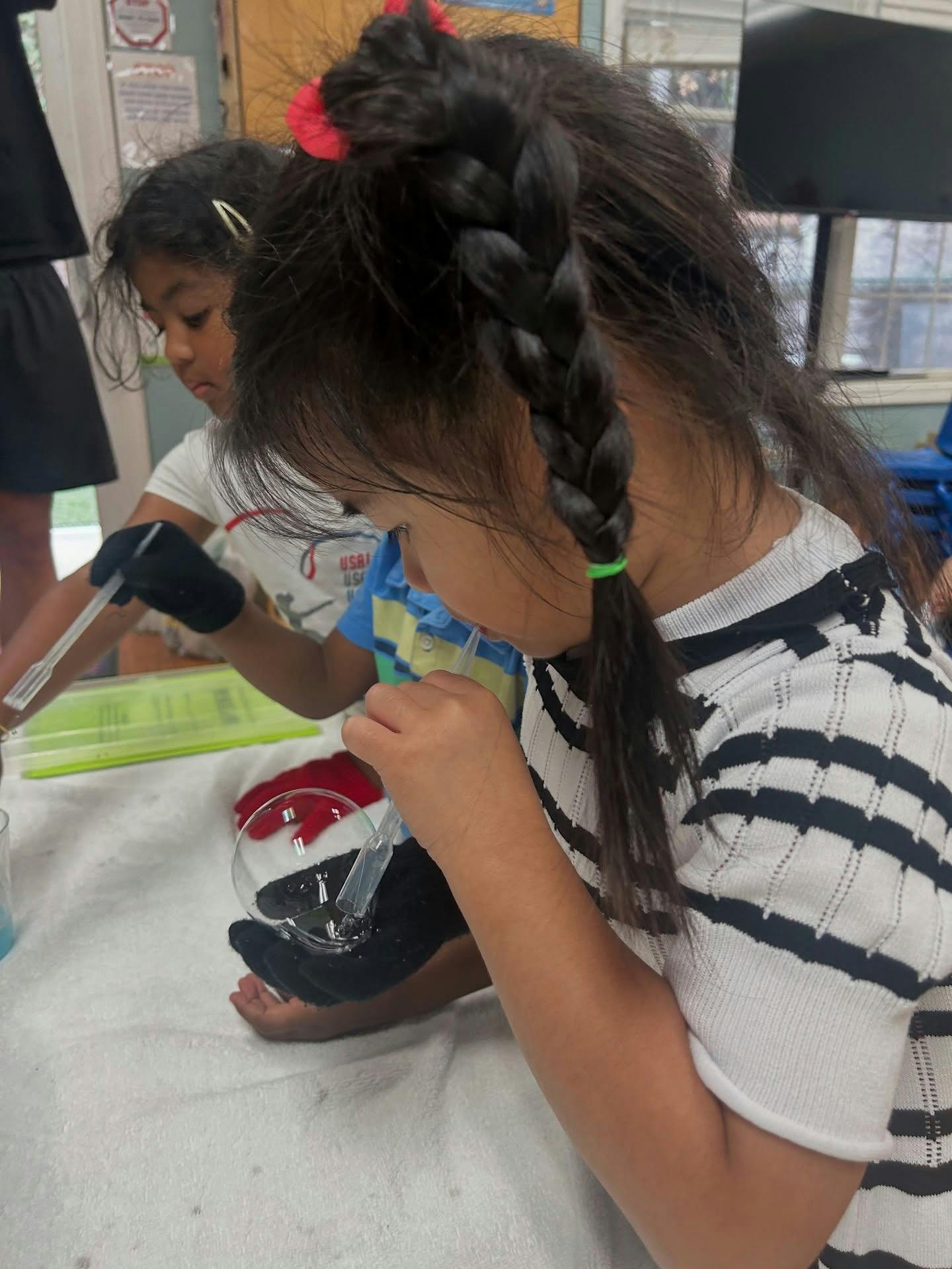 Two children working with pipettes and beakers