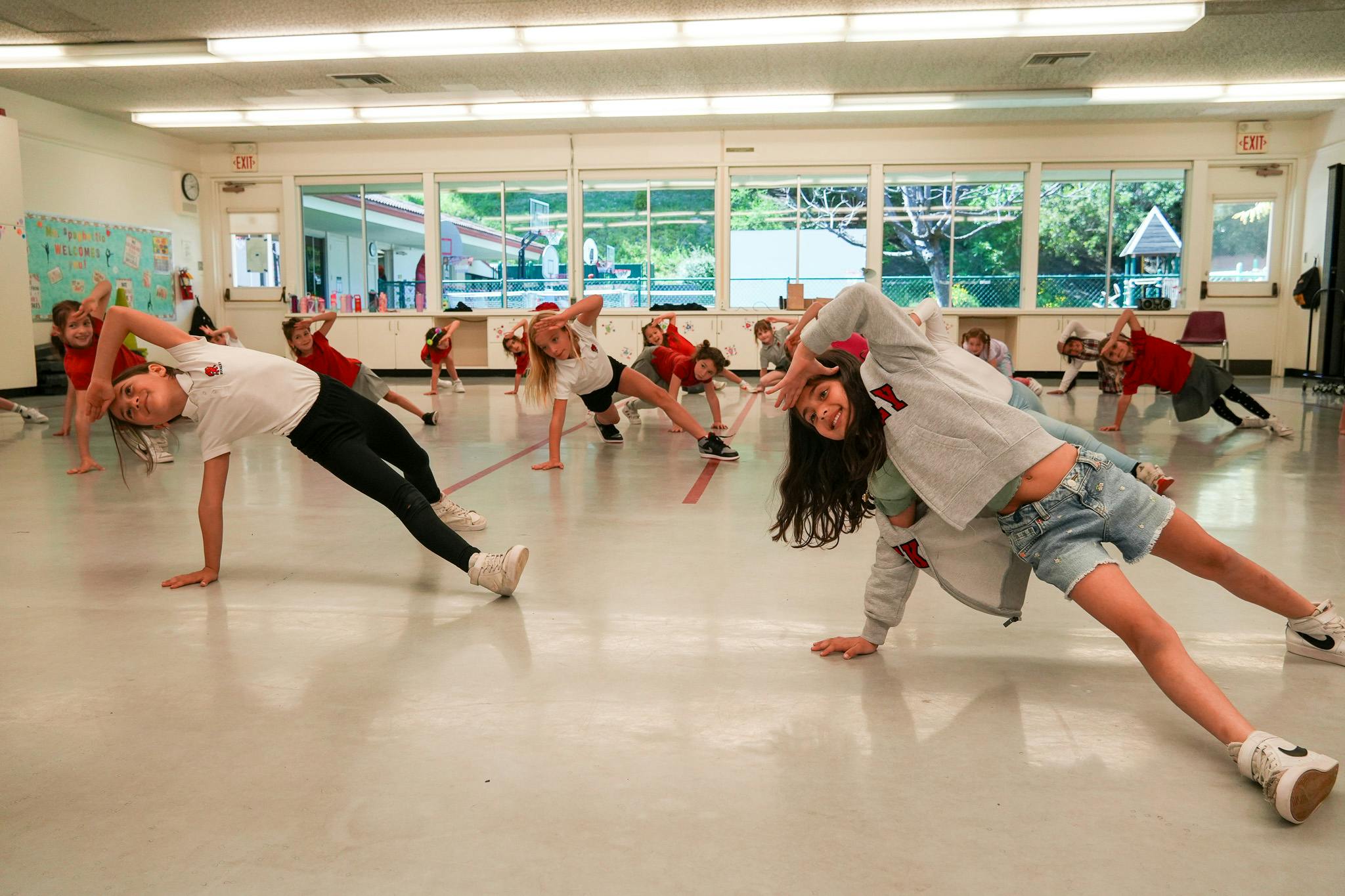 Group of children doing push-ups or exercises in a school hall