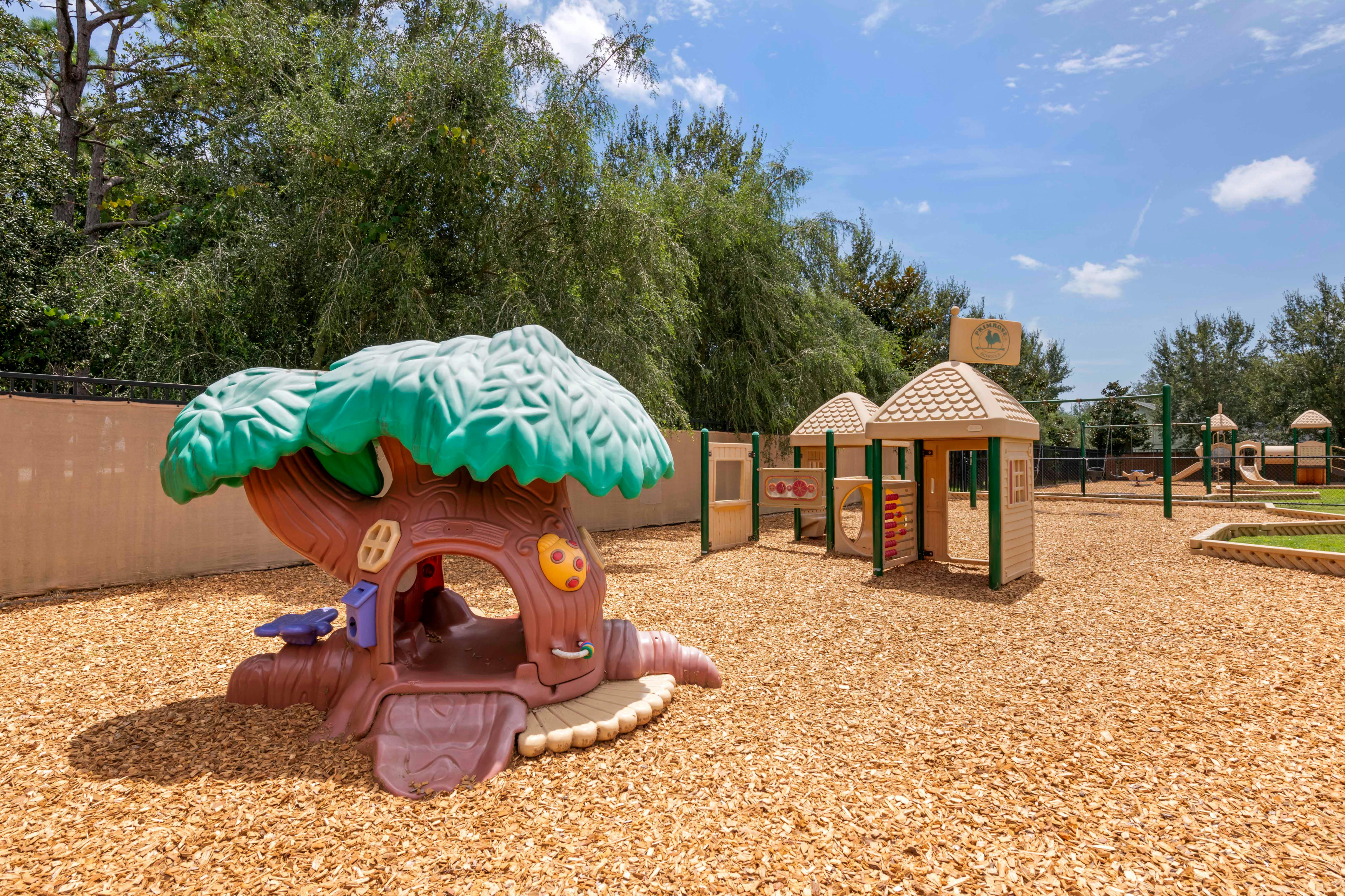 Outdoor playground with a treehouse structure and other play equipment
