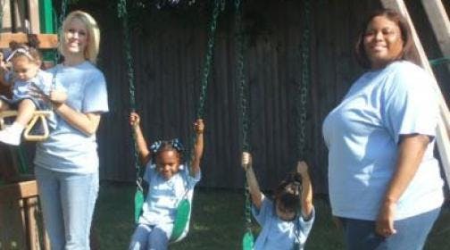 Two people and two children on a swing set