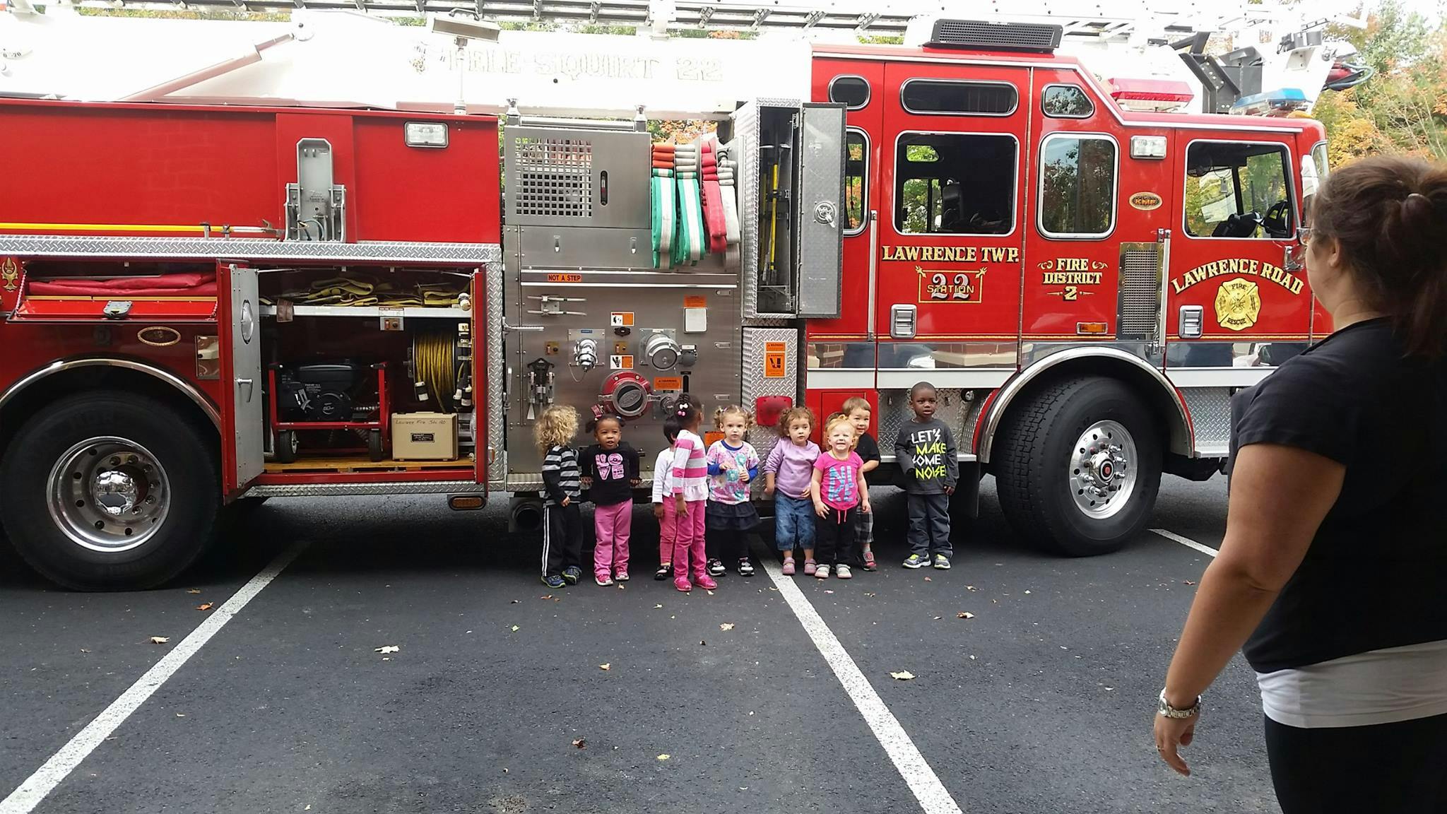 Children standing in front of a fire truck