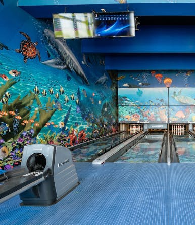 Bowling alley with underwater mural and screens showing two lanes