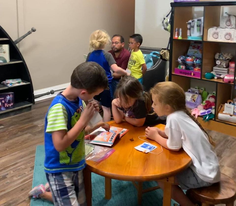 Children and adults gathered around a small table