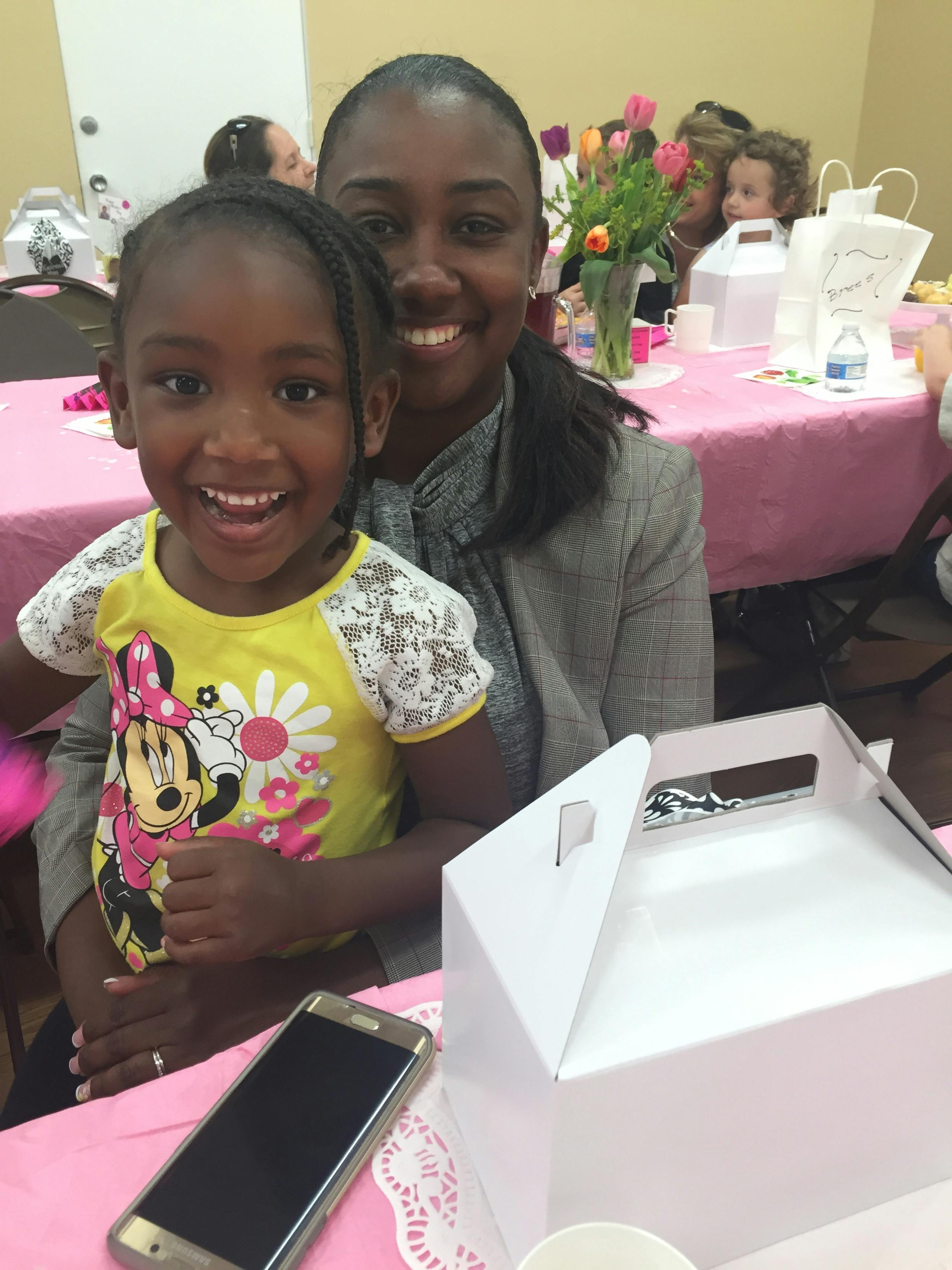 Person and child smiling at a table