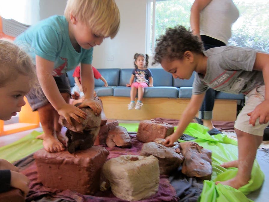 Children playing with clay in a classroom
