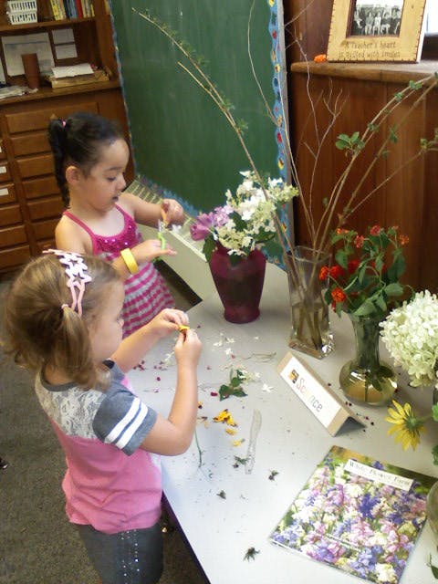 Two children arranging flowers on a table