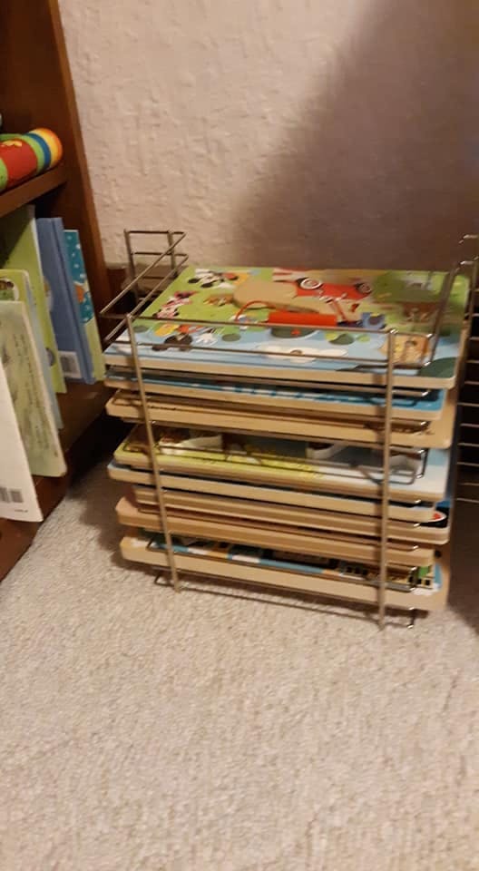 Stack of children's puzzles in a metal rack