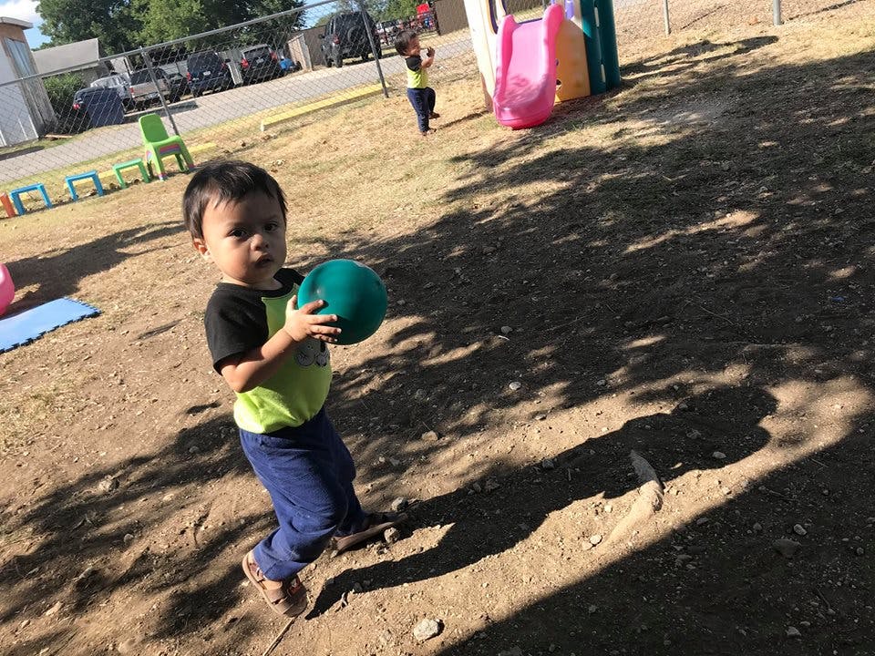 Child holding a ball on a playground