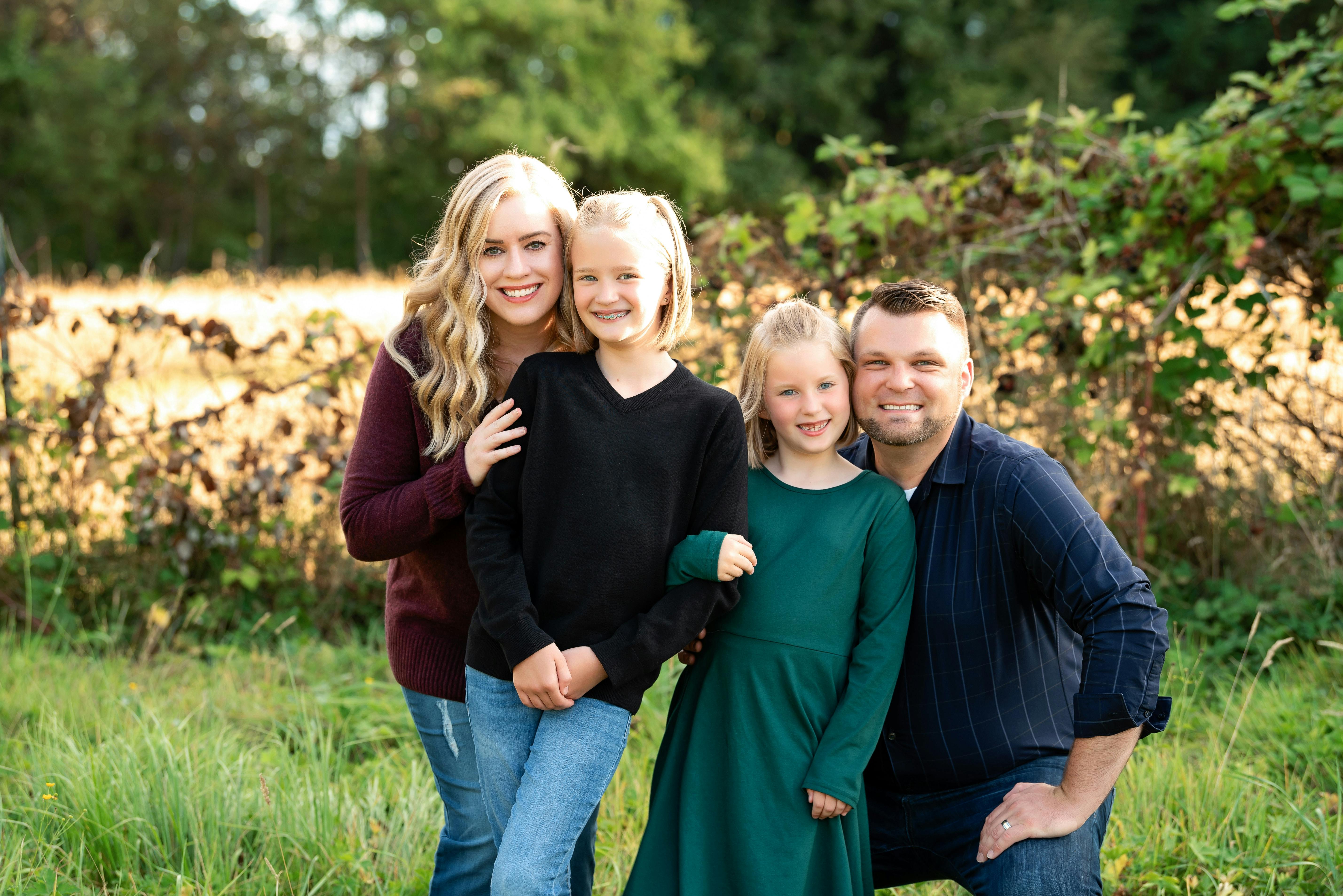 Two adults and two children posing outdoors