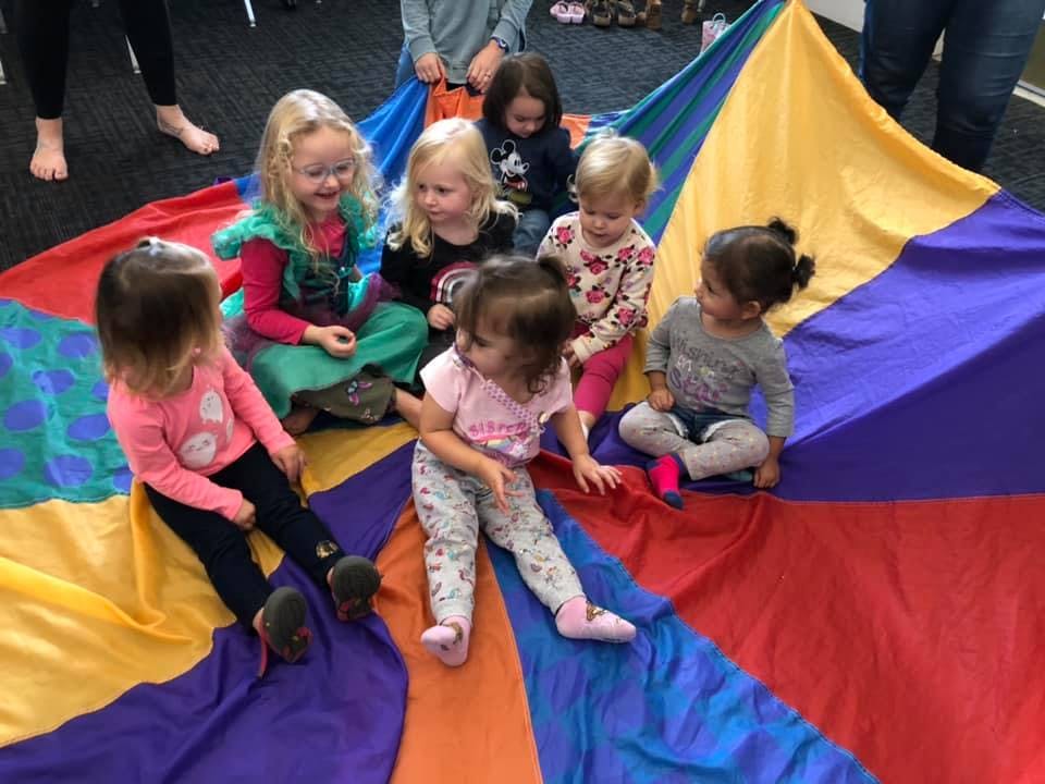 Group of children sitting on a colorful parachute