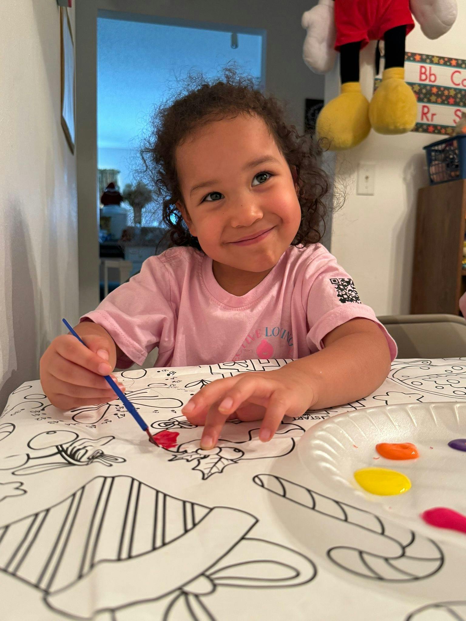 Child painting a coloring sheet