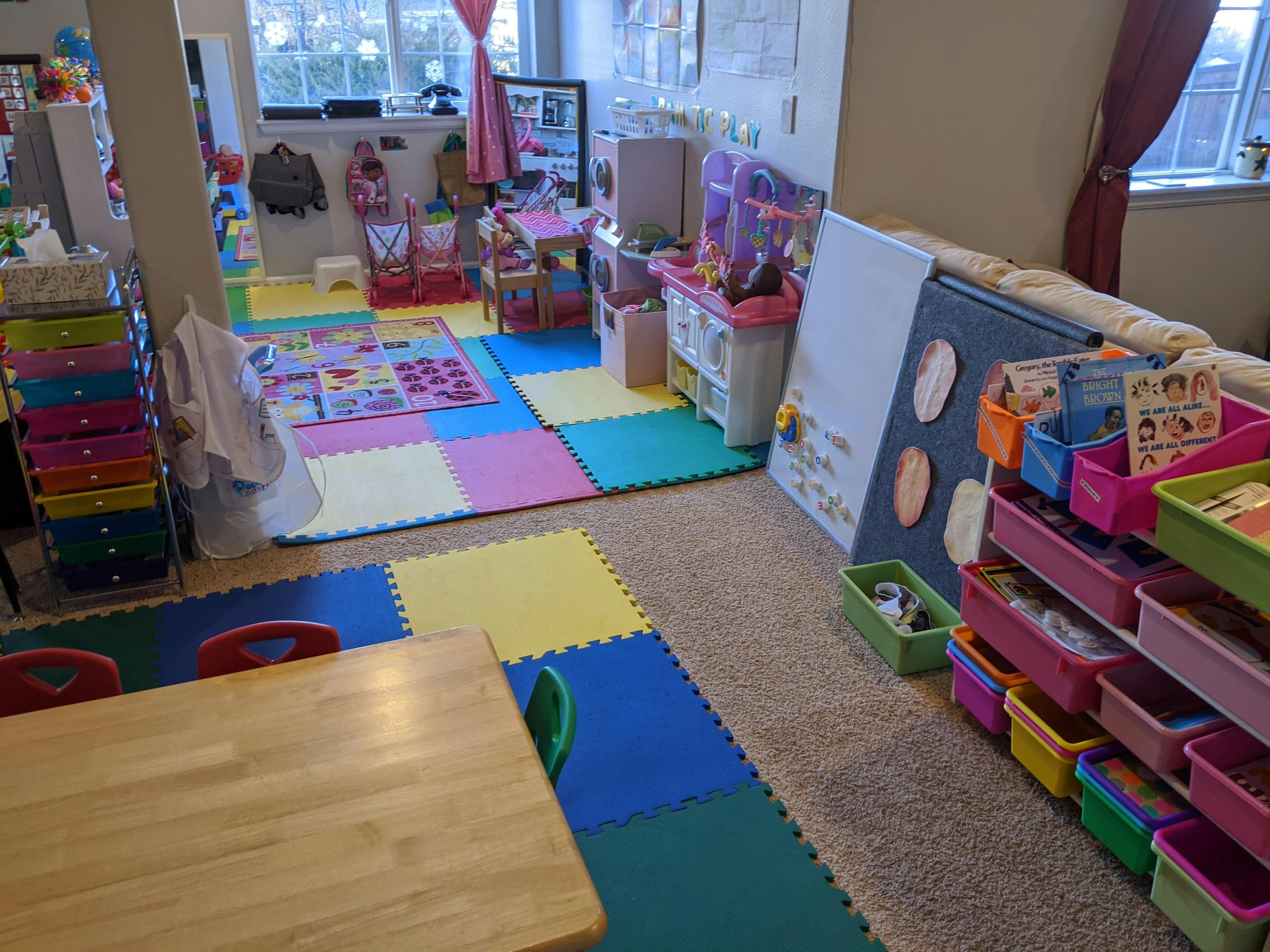 Playroom with colorful floor mats, toys, and storage bins