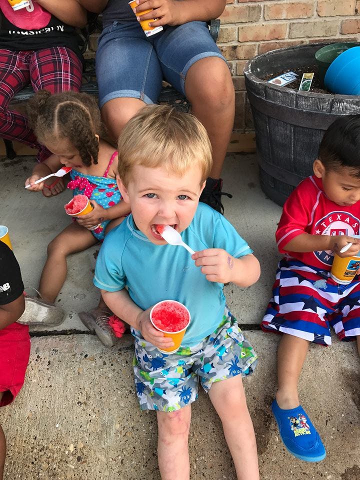 Child eating a frozen treat with a spoon