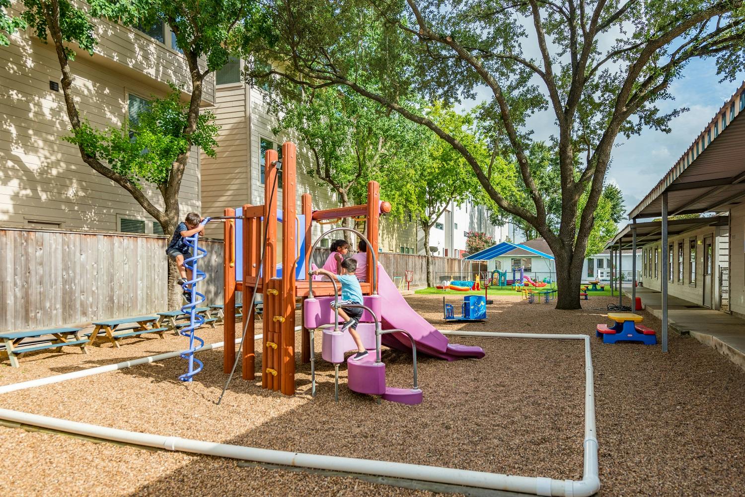 Children playing on a playground structure with slides and climbers