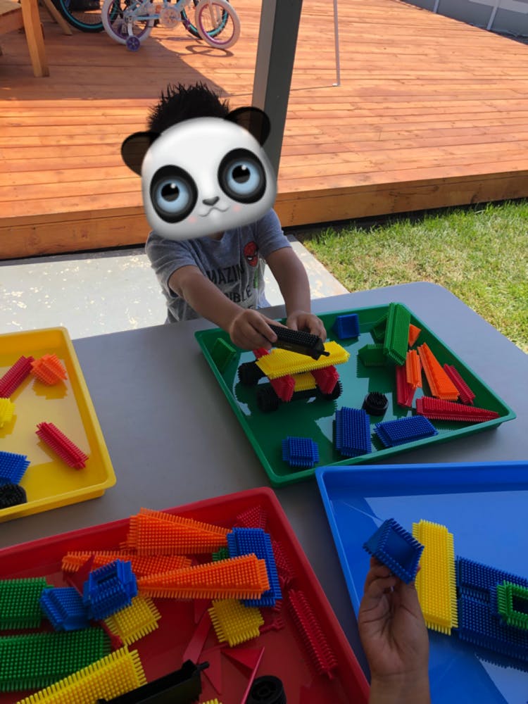 Child playing with colorful building blocks on a table