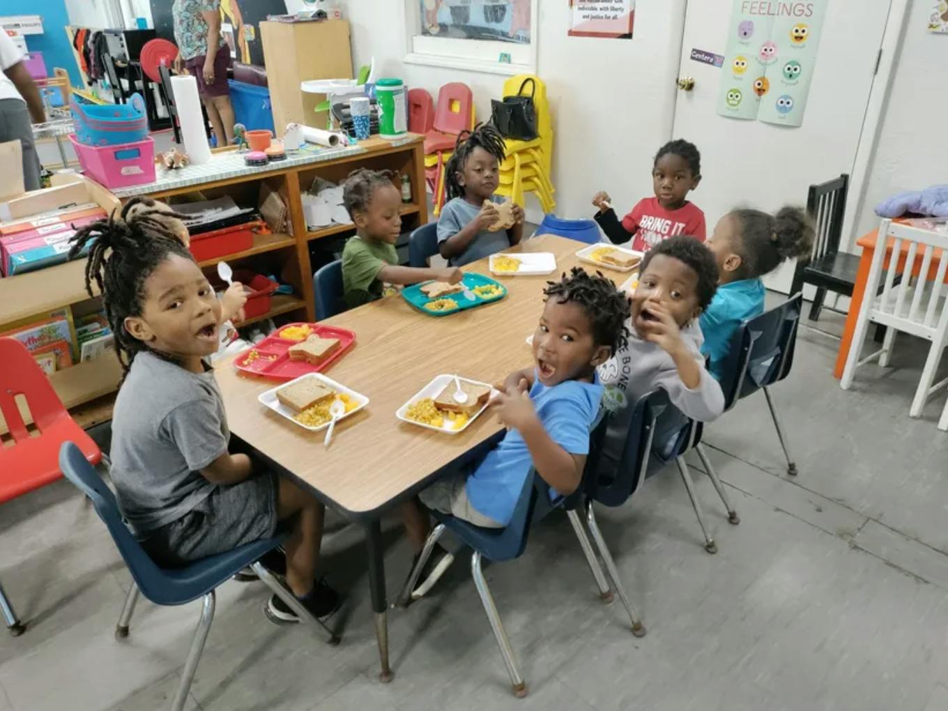 Children eating at a table in a classroom