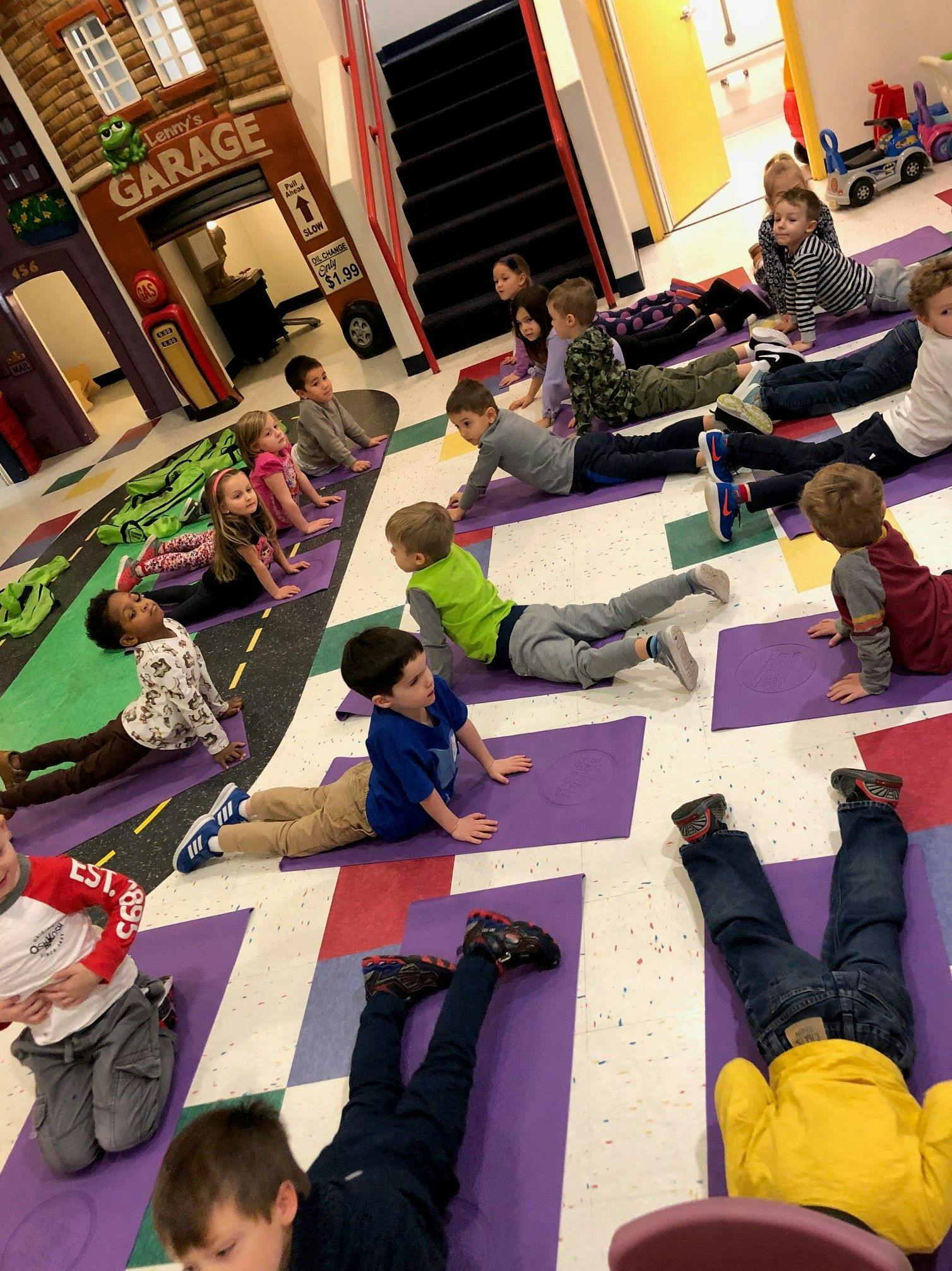 Children lying on purple mats on the floor